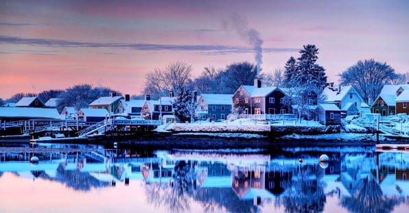 Downtown Portsmouth, New Hampshire skyline at twilight with snow by river
