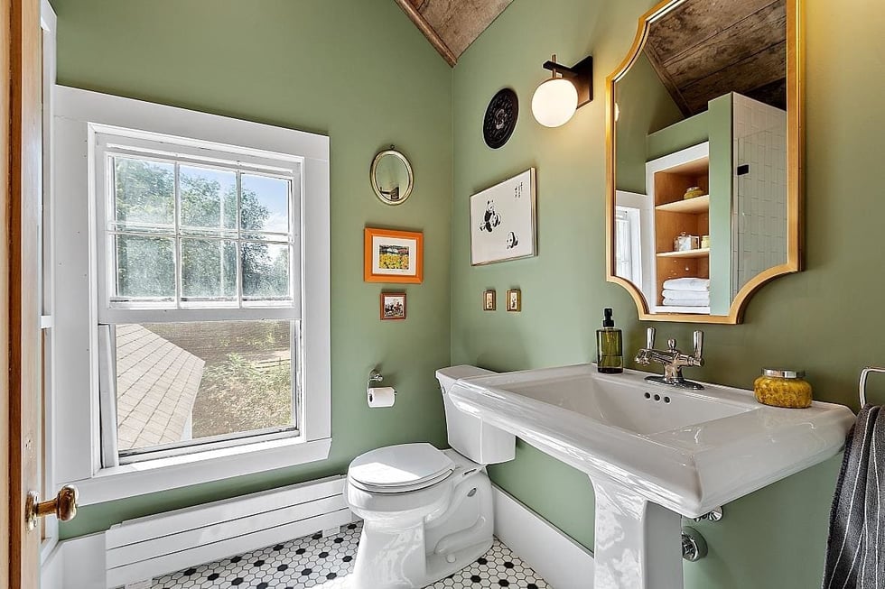 Farmhouse-style bathroom remodel in New Hampshire with green walls and penny tile flooring