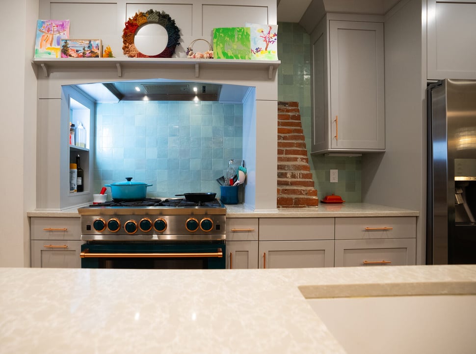 Modern kitchen with teal backsplash, copper accents, and exposed brick, designed by Oxland Builders in New Hampshire