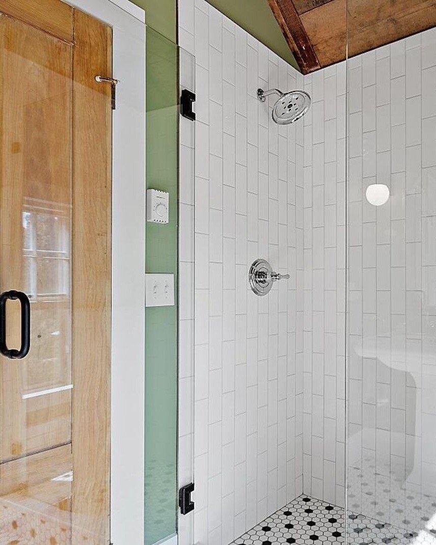 Small bathroom with unique wallpaper and vintage-style fixtures, designed by Oxland Builders in New Hampshire