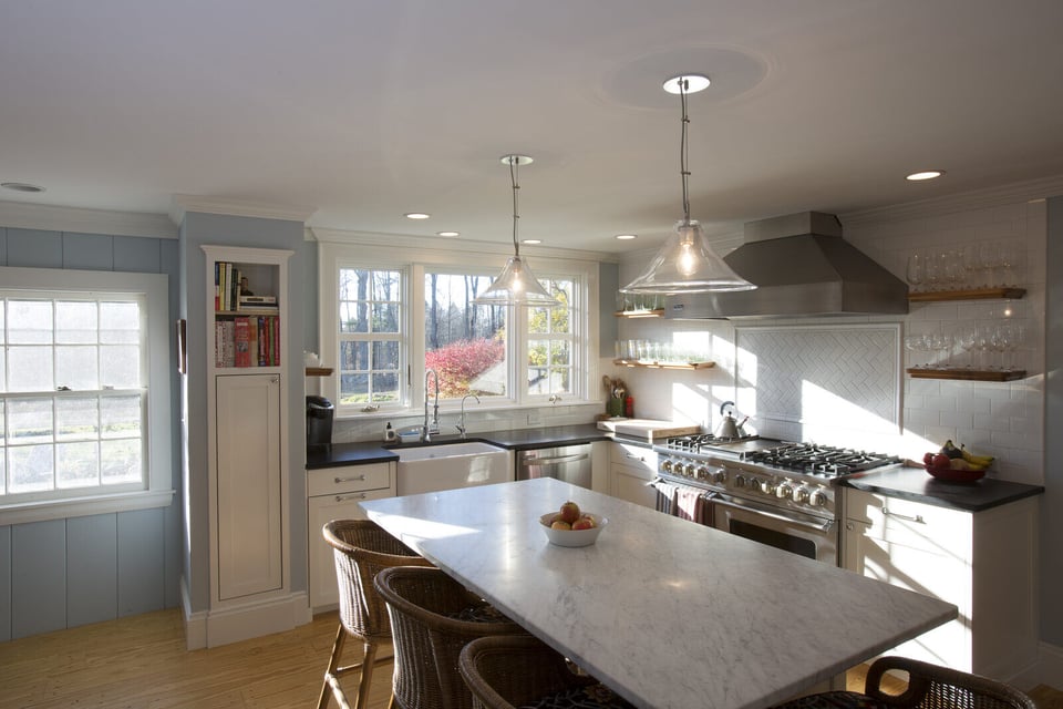 Bright and modern kitchen remodel in New Hampshire by Oxland Builders featuring an island and stainless steel appliances