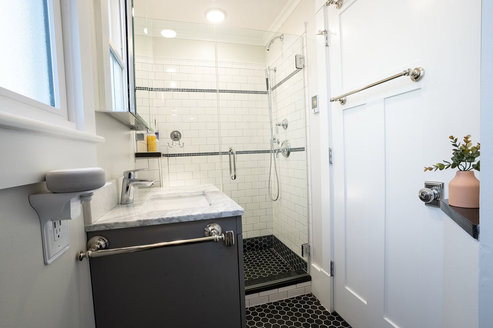 Luxurious bathroom remodel with a walk-in glass shower and modern black tile flooring in New Hampshire by Oxland Builders