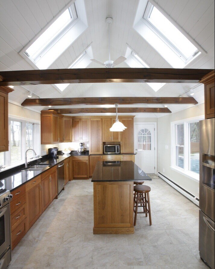 A kitchen remodel in New Hampshire by Oxland Builders with a mix of natural wood tones and bright skylights