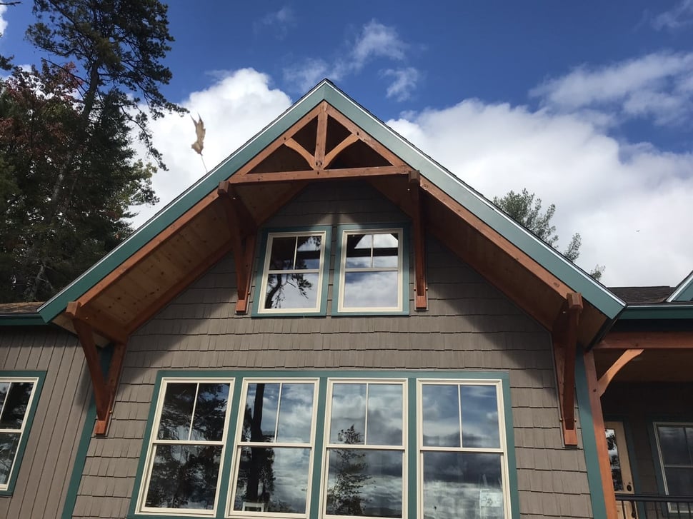 Gabled roof exterior with green-blue detailing on NH home by Oxland Builders