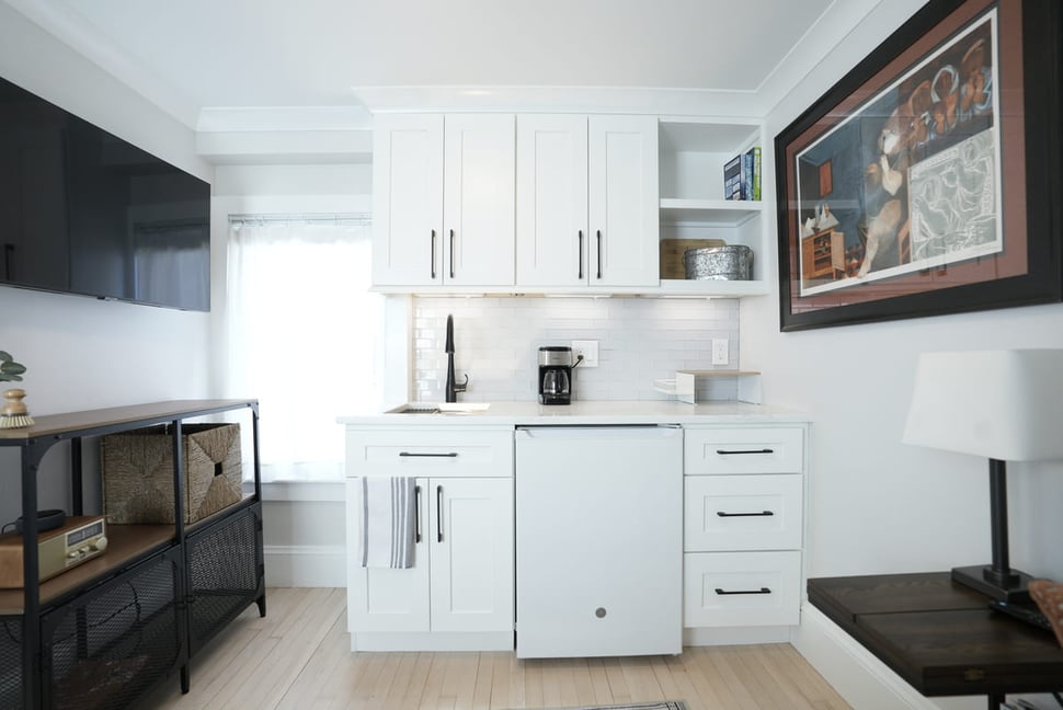 Modern drink station in Seacoast, NH home with white cabinets and black fixtures
