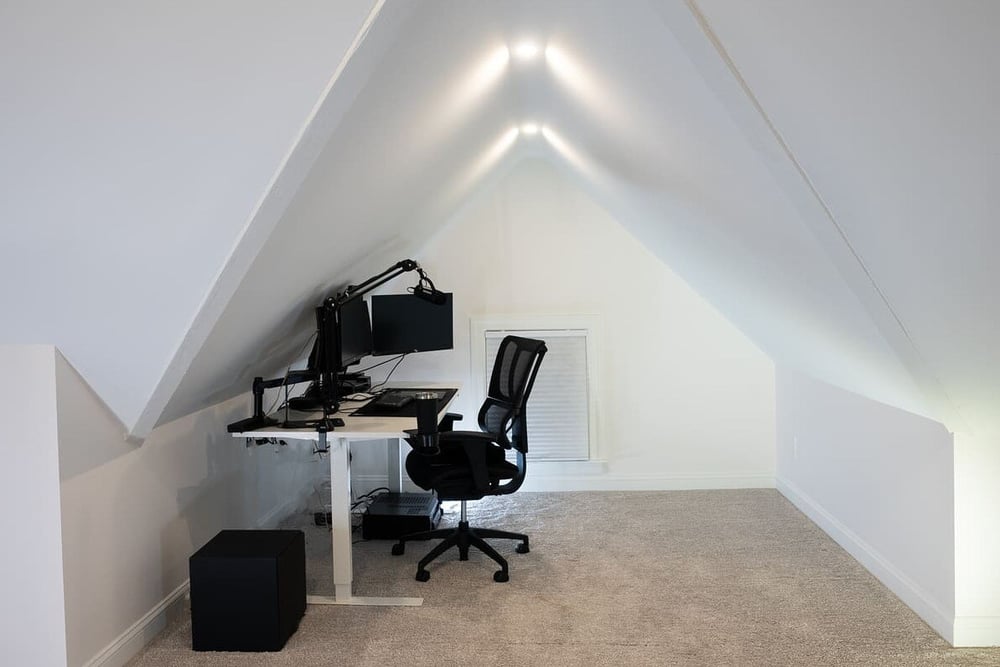 Office chair and desk in finished attic remodel with angled ceiling by Oxland Builders with vent