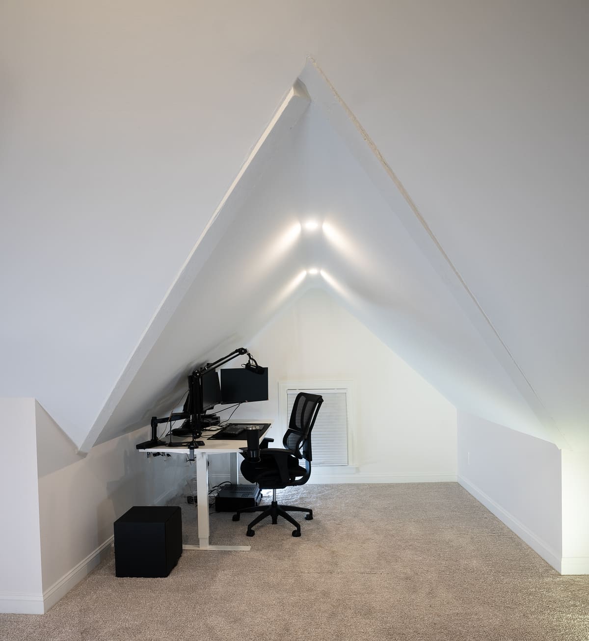 Office chair and desk in finished attic remodel with angled ceiling by Oxland Builders