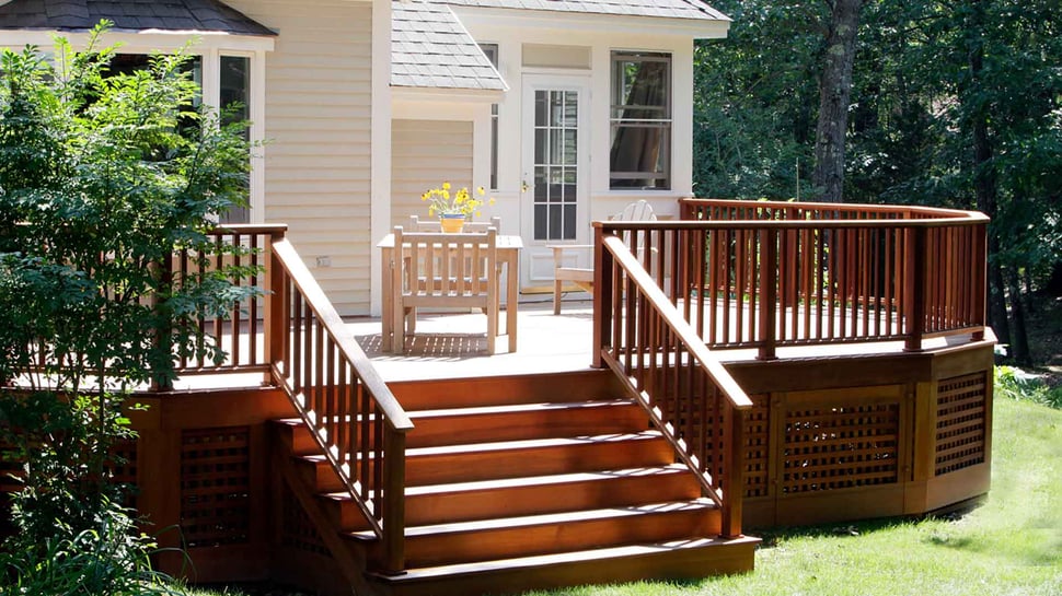 Exterior of Raised Wooden Deck Addition on Back of House. Six Steps With Handrails on Both Sides and Outdoor Furniture