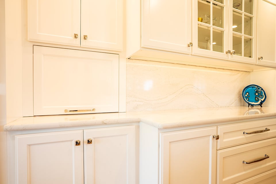 Seamless built-in cabinetry with clean white finishes and glass-front uppers in a coastal New Hampshire home