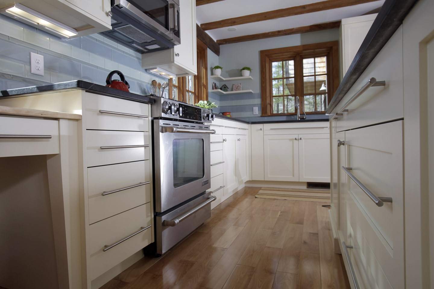 Flat and Recessed Kitchen Cabinetry. Wood Flooring. Stainless Steel Oven, and Microwave Featured 
