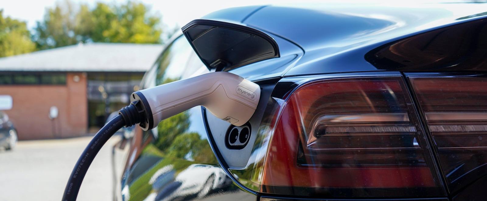 black electric car being charged at home charging station in new hampshire (1)