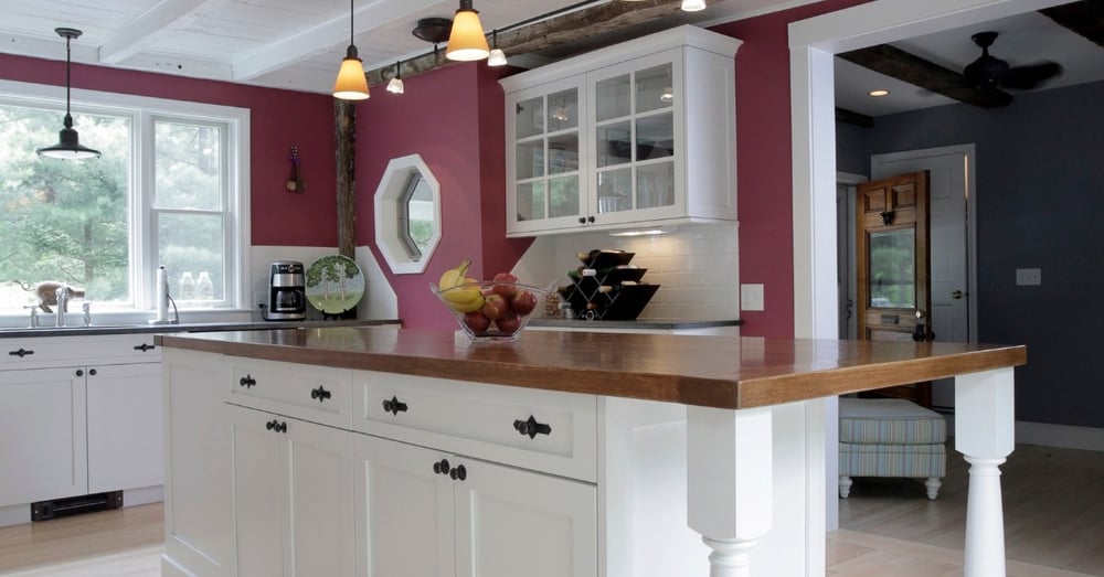 Butcher block island in kitchen remodel with white shaker cabinets