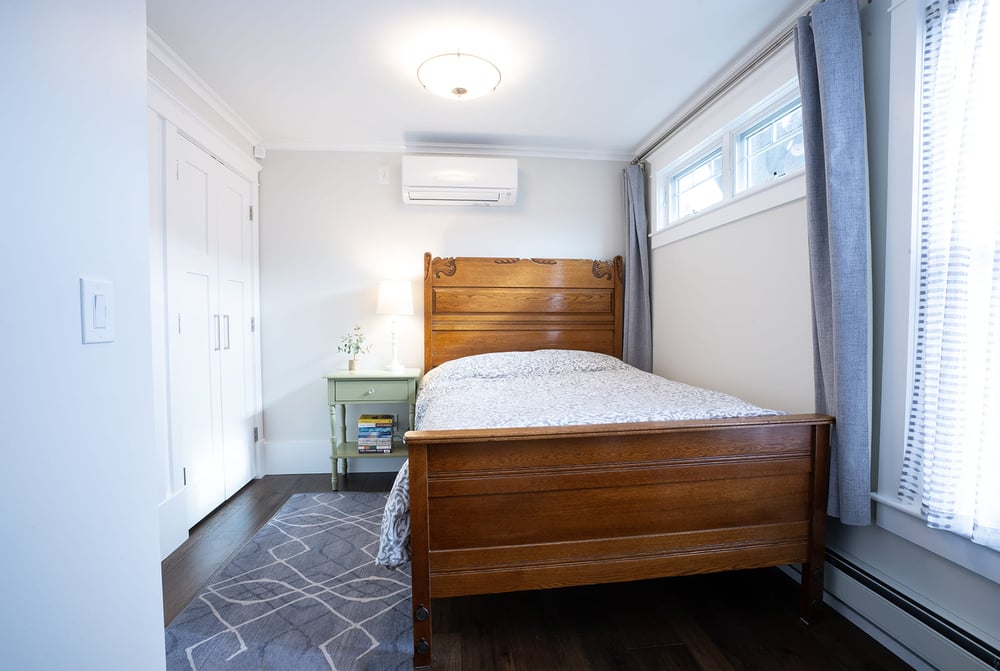 Main floor bedroom with bedside table and double door closet