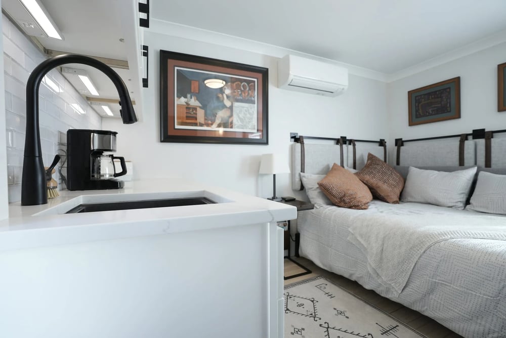 matte black sink faucet and cozy bed in remodel in seacoast new hampshire