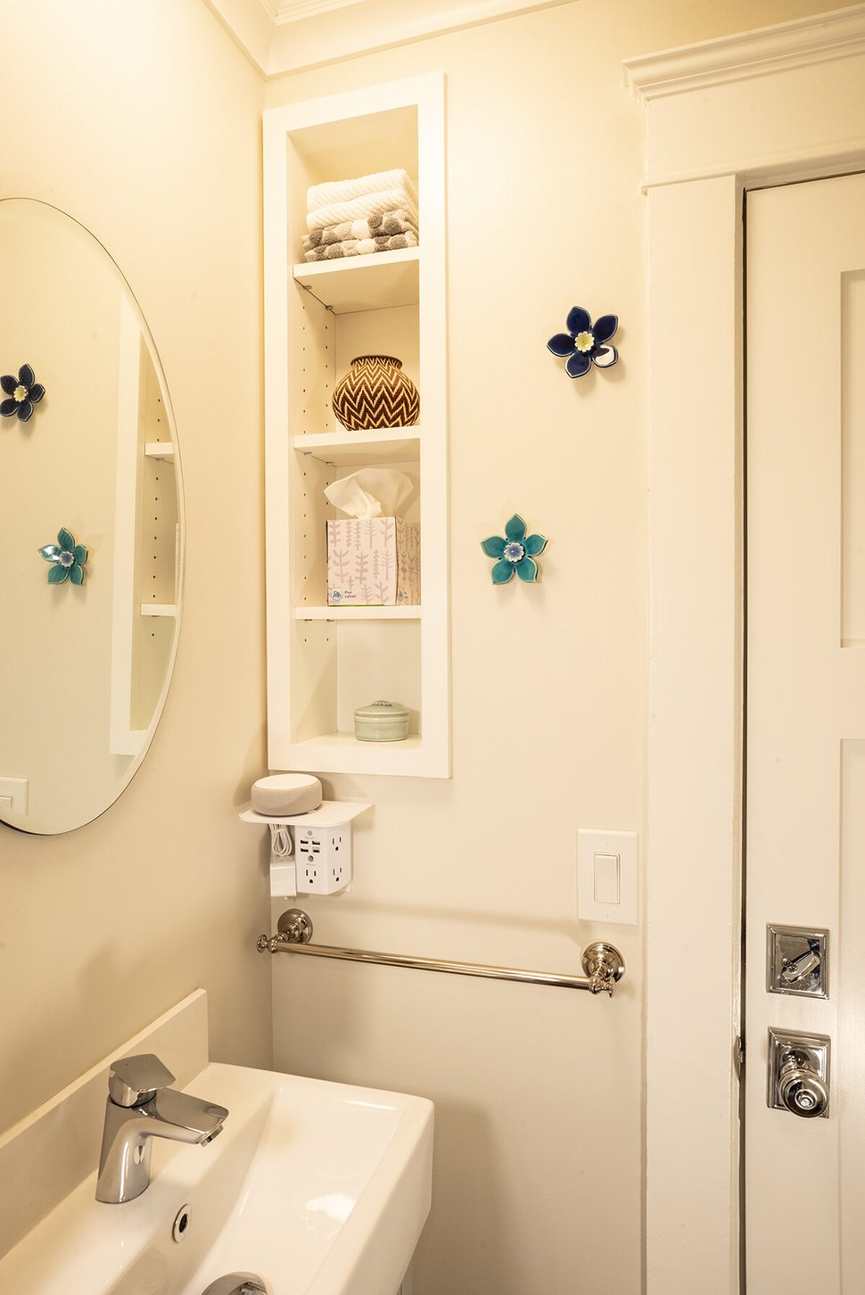 Custom storage shelf and circular mirror in bathroom remodel